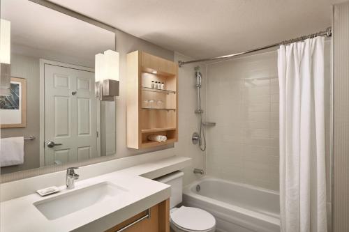 a bathroom with a tub and a sink and a toilet at Delta Hotels by Marriott Whistler Village Suites in Whistler