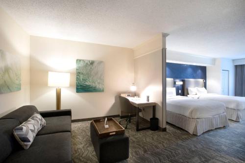 um quarto de hotel com uma cama e um sofá em SpringHill Suites by Marriott Savannah I-95 South em Savannah