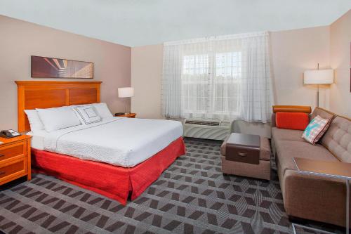 une chambre d'hôtel avec un lit et un canapé dans l'établissement TownePlace Suites Knoxville Cedar Bluff, à Knoxville