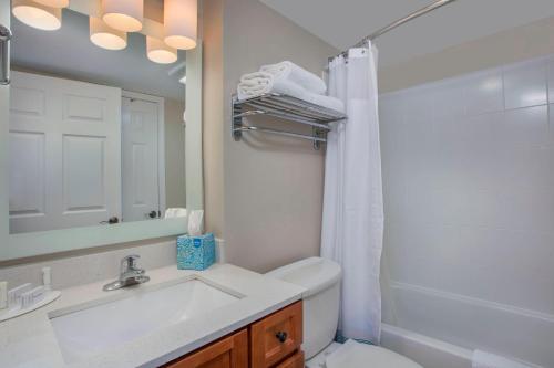 uma casa de banho com um lavatório, um WC e um espelho. em TownePlace Suites Knoxville Cedar Bluff em Knoxville