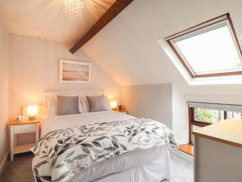 a bedroom with a bed and a skylight at Gamekeepers Cottage in Conwy
