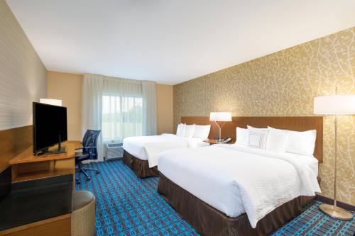 a hotel room with two beds and a flat screen tv at Fairfield Inn & Suites by Marriott Bloomsburg in Bloomsburg