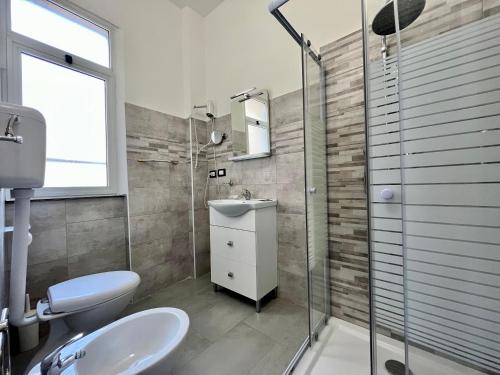 a bathroom with a toilet and a sink and a shower at Hotel Alla Fontanella in Alassio