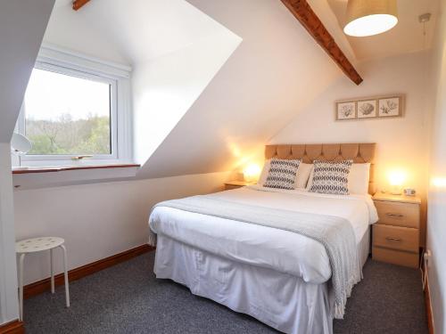 a bedroom with a bed and a window at Oak Cottage in Conwy