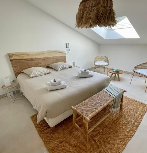 une chambre avec un grand lit avec deux serviettes dessus dans l'établissement Paillote Perchée à 180 ° sur la mer, à Ajaccio