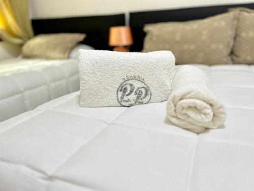 a towel and a pillow on a bed at Hotel Perla del Plata in Colonia del Sacramento