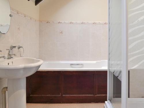 a bathroom with a sink and a bath tub at The Old Workshop - Ukc3740 in Bawdeswell