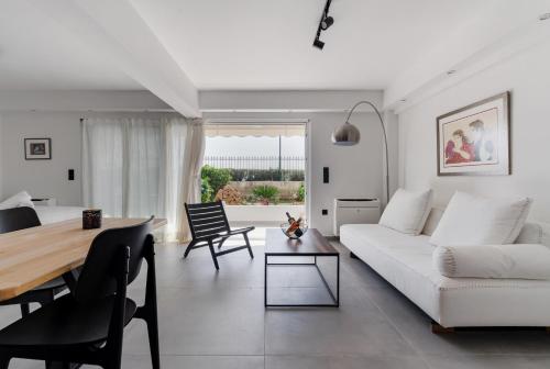 a living room with a white couch and a table at Athens-Riviera luxury apartment sea view Voula in Athens