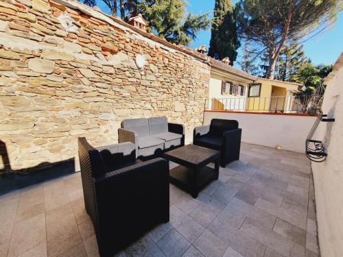 a patio with chairs and a stone wall at Allegra Toscana - Affittacamere Guest house Arezzo in Arezzo