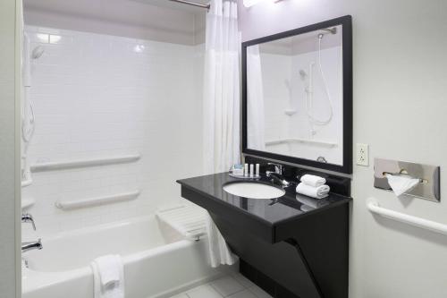 a bathroom with a sink and a tub and a toilet at Fairfield Inn & Suites Kansas City Overland Park in Overland Park