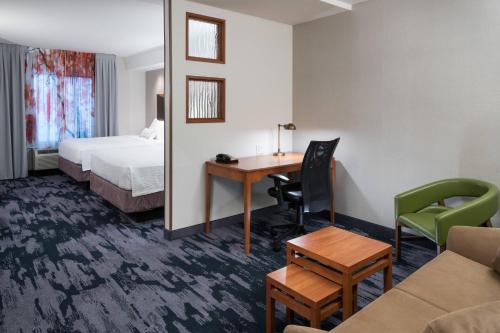 um quarto de hotel com uma secretária e uma cama em Fairfield Inn & Suites Kansas City Overland Park em Overland Park