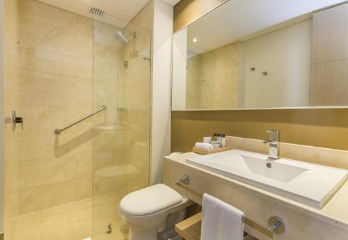 a bathroom with a sink and a toilet and a shower at Cosmos Pacifico Hotel in Buenaventura