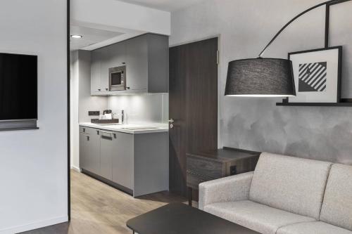 a living room with a couch and a kitchen at Residence Inn by Marriott Munich Ostbahnhof in Munich