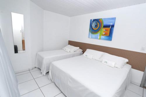 - une chambre avec 2 lits et un tableau mural dans l'établissement Pousada Oma Helga, à Pomerode