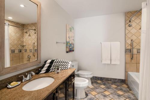 a bathroom with a sink and a toilet and a tub at Marriott St. Kitts Beach Club in Frigate Bay