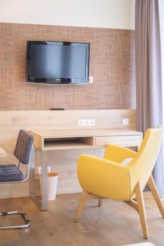 a living room with a desk and a tv on a wall at PM-PremiumAPART Strassgang in Graz