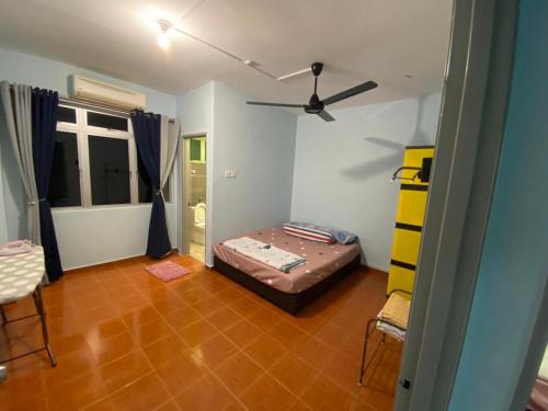 a bedroom with a bed and a ceiling fan at Mr Singh Homestay in Kampong Tanah Merah