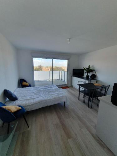 une chambre avec un lit et une table avec des chaises dans l'établissement appartement remblai saint hilaire de riez, à Saint-Hilaire-de-Riez