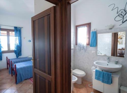 ein Badezimmer mit einem Waschbecken, einem WC und einem Waschbecken in der Unterkunft Maiorca Sea-view Apartment in Budoni