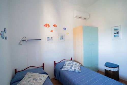 1 Schlafzimmer mit 2 Einzelbetten und einem Schrank in der Unterkunft Maiorca Sea-view Apartment in Budoni