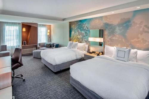 une chambre d'hôtel avec deux lits et un canapé dans l'établissement Courtyard by Marriott Raleigh Cary/Parkside Town Commons, à Cary