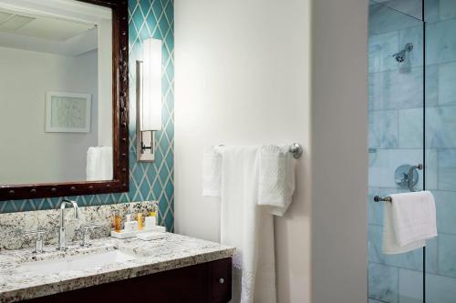 a bathroom with a sink and a shower and a mirror at Triada Palm Springs, Autograph Collection in Palm Springs