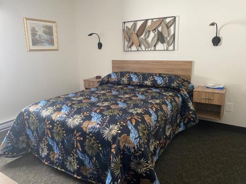 a bedroom with a bed with a floral bedspread at Ermitage Saint-Antoine in Lac-Bouchette