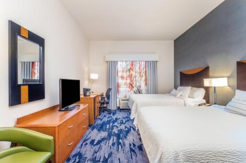 a hotel room with two beds and a television at Fairfield Inn and Suites by Marriott Madison East in Madison