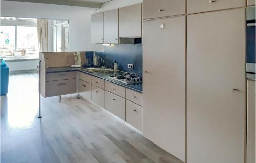 Una cocina con gabinetes blancos y un fregadero. en Elfrank, en Bergen aan Zee