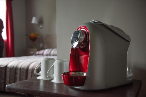 a red mixer sitting on a table next to a bed at Ermitage Saint-Antoine in Lac-Bouchette