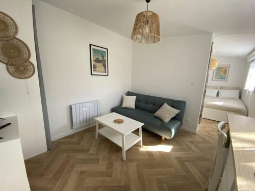 ein Wohnzimmer mit einem Sofa und einem Tisch in der Unterkunft Studio au calme St Marc sur Mer in Saint-Nazaire