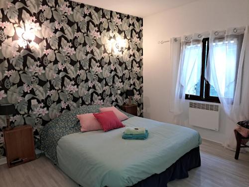 - une chambre avec un lit et un papier peint floral dans l'établissement L'Auberge, 