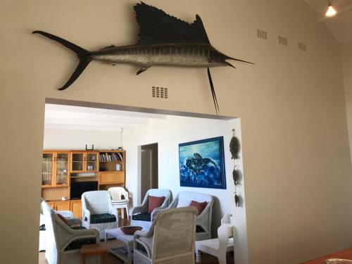 a living room with a fish hanging on the wall at La Mer, a beautiful beachfront home in Sandbaai in Hermanus