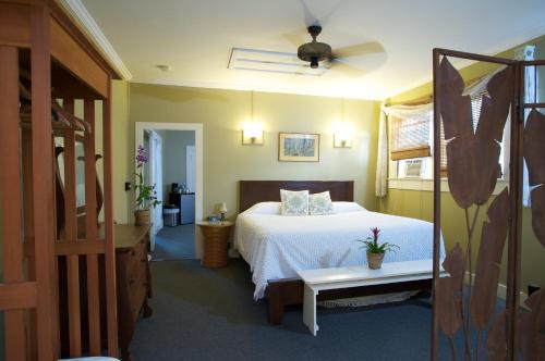 a bedroom with a bed and a ceiling fan at West Kauai Lodging in Waimea