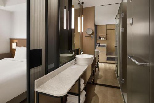 a hotel bathroom with a sink and a bed at AC Hotel by Marriott Seoul Gangnam in Seoul