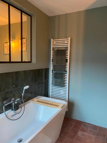a bath tub in a bathroom with a window at La benjamine in Cany-Barville