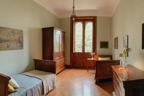 um quarto com uma cama, uma secretária e uma janela em Villa Biancardi - Un posto un Sogno em Codogno