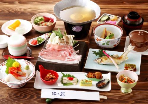 a table with plates of food and bowls of food at Hotel Shirakawa Yunokura in Nikko