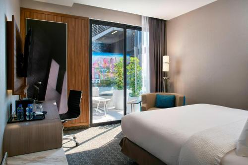 una camera d'albergo con un letto e una porta scorrevole in vetro di Courtyard by Marriott Mexico City Toreo a Città del Messico