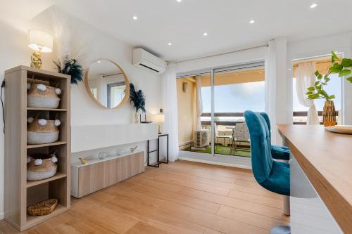 une cuisine et une salle à manger avec une table et une chaise bleue dans l'établissement Le duplex village naturiste vue mer, au Cap d'Agde