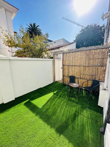 a backyard with two chairs and a fence at MAKTVB Europa - Hostal Boutique in Santiago