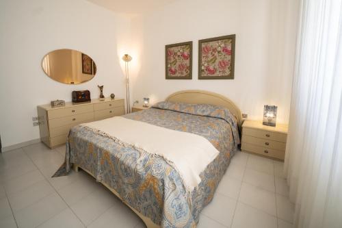een slaapkamer met een bed, 2 dressoires en een spiegel bij Suite Leone in Martina Franca