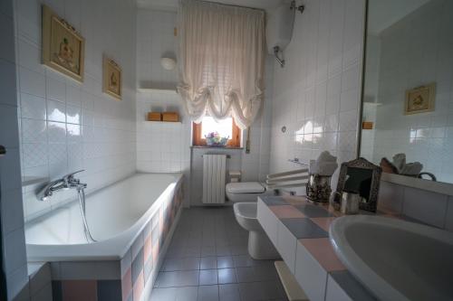 een badkamer met 2 wastafels, een bad en 2 toiletten bij Suite Leone in Martina Franca
