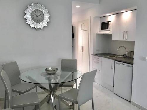 a kitchen with a table and chairs and a clock on the wall at Costa Adeje Modern Studio, close to the beach in Adeje