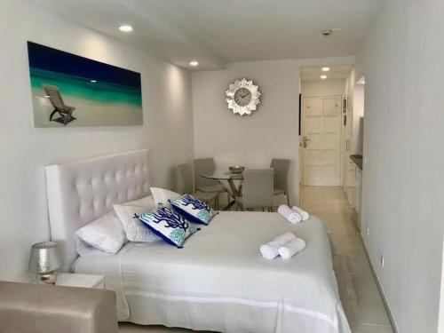 1 dormitorio con 1 cama blanca grande y toallas. en Costa Adeje Modern Studio, close to the beach en Adeje