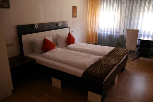 a bedroom with a large bed with red pillows at Gasthaus Zur Stadt Triberg in Schonach