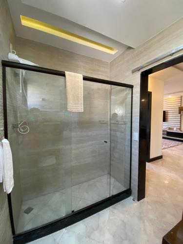 a glass shower in a bathroom with a tile floor at Local 401 Apartment in Rio de Janeiro