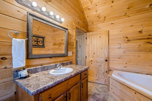 ein Blockhausbad mit einem Waschbecken und einer Badewanne in der Unterkunft Blue Ridge Bear Bungalow in Blue Ridge