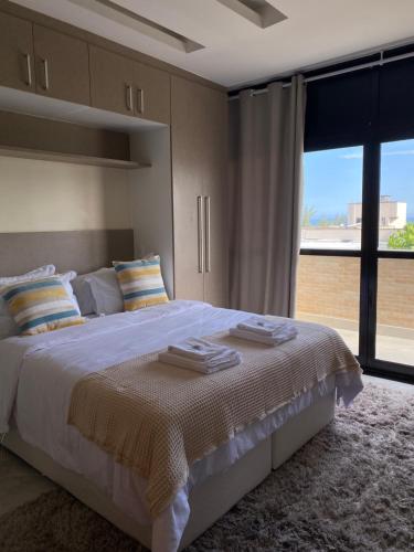 a bedroom with a large bed and a large window at Local 401 Apartment in Rio de Janeiro