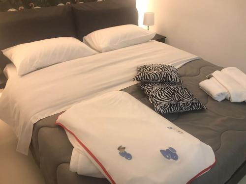 1 cama grande con toallas y almohadas en IL VICOLETTO Luxury Apartments, en Augusta